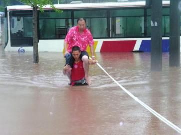 消防員轉移公交車上被困的乘客。（自貢消防支隊提供)