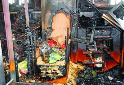 大圖：消防隊員正在救火。 小圖：大火將船艙燒得一片狼藉。 葉方龍 攝