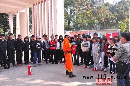 消防官兵正在給同學(xué)們講解滅火器的使用方法