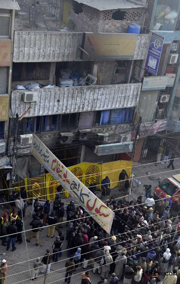 12月30日，在巴基斯坦拉合爾，人們聚集在發生火災的購物中心附近