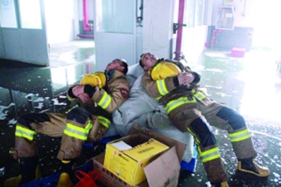 地面上都是水，消防戰(zhàn)士躺在沙袋上休息